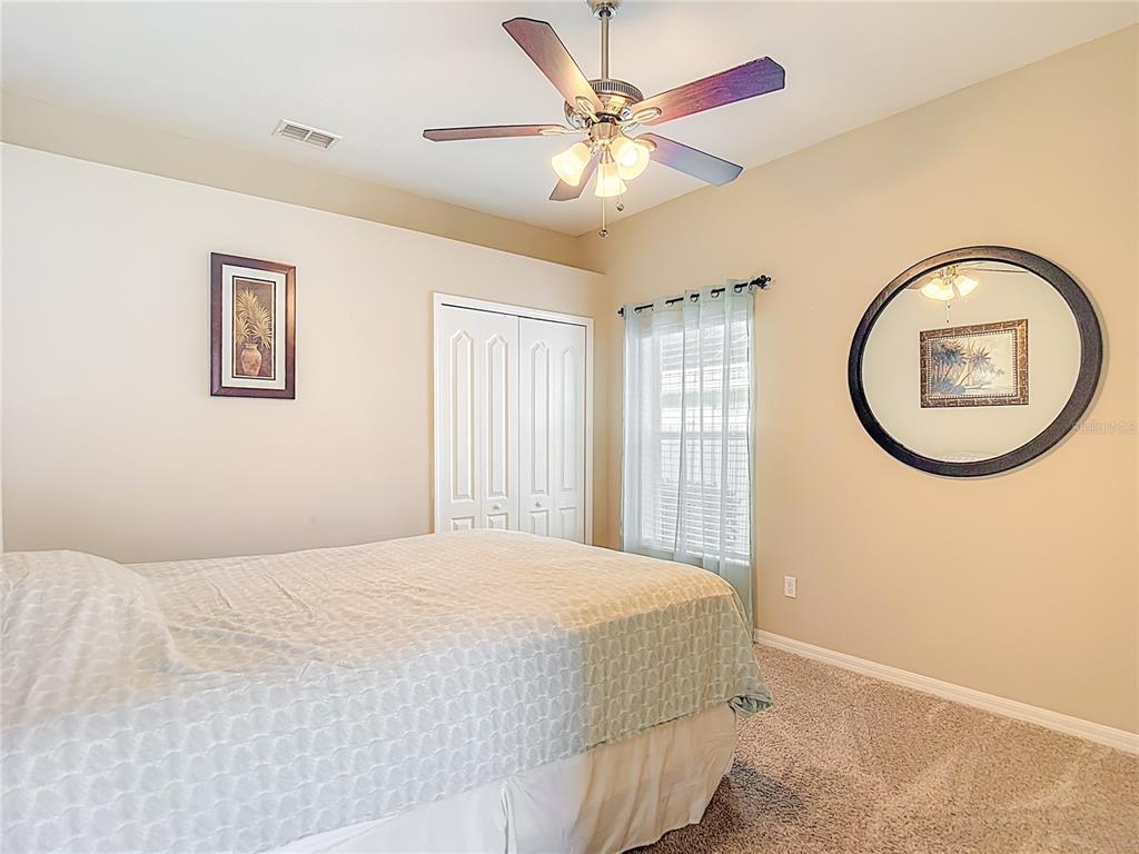 8942 Sandusky Lane New Port Richey, FL 34654 - Photo 31 of 87 a bedroom with a large bed and a chandelier