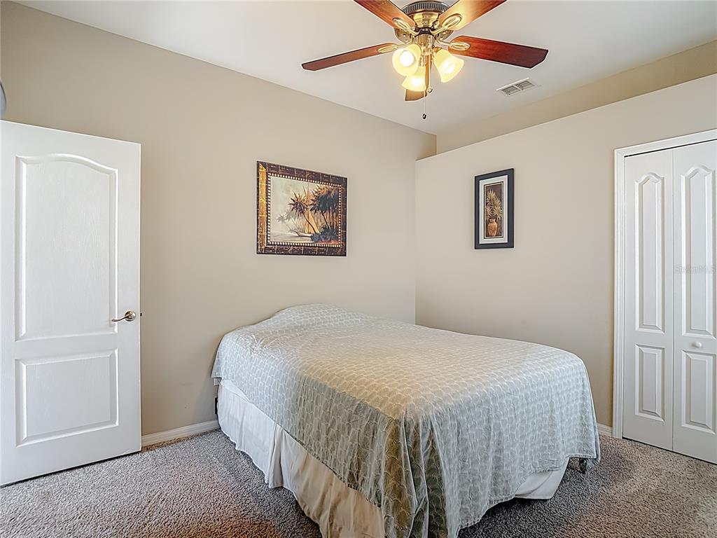 8942 Sandusky Lane New Port Richey, FL 34654 - Photo 32 of 87 a bedroom with a bed and a chandelier