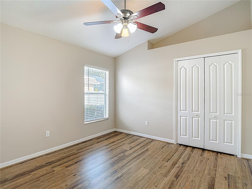 8942 Sandusky Lane New Port Richey, FL 34654 - Photo 59 of 87 an empty room with wooden floor chandelier fan and windows