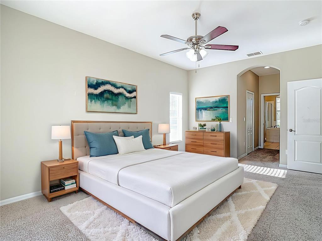 8942 Sandusky Lane New Port Richey, FL 34654 - Photo 8 of 87 a bedroom with a large bed a chandelier and a chandelier