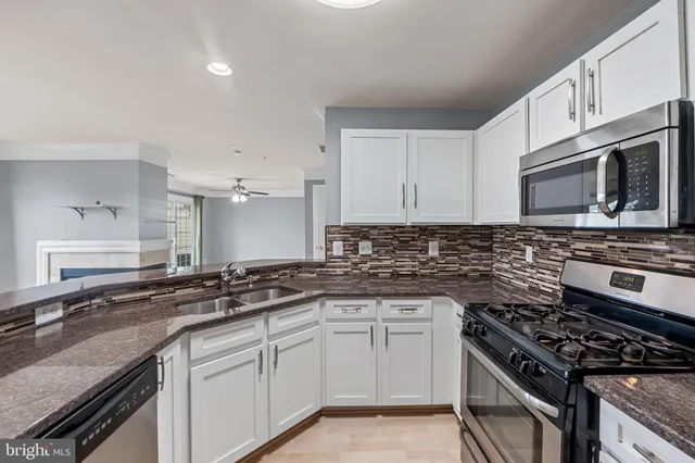 a kitchen with granite countertop a sink dishwasher stove and oven