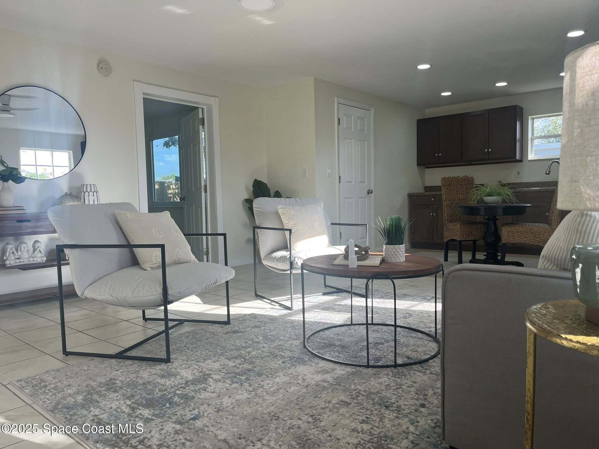 2027 Wallace Avenue, Unit IN Melbourne, FL 32935 - Photo 4 of 5 a living room with furniture a large window and a fireplace