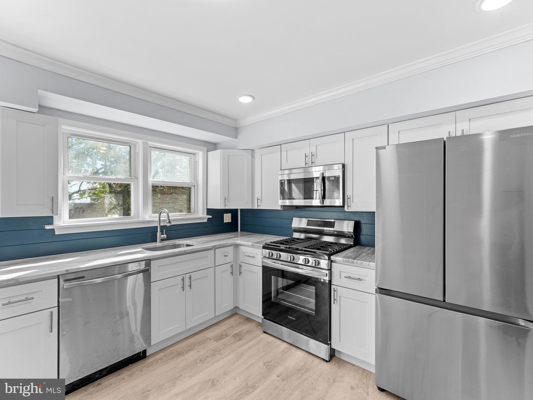 125 White Avenue Marcus Hook, PA 19061 - Photo 9 of 23 a kitchen with stainless steel appliances granite countertop a stove a sink and a refrigerator