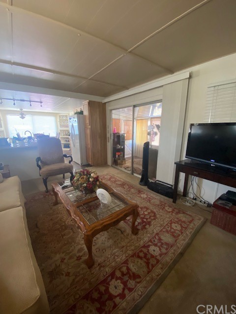 12874 California Street, Unit 48 Yucaipa, CA 92399 - Photo 8 of 21 a living room with furniture a flat screen tv and a table