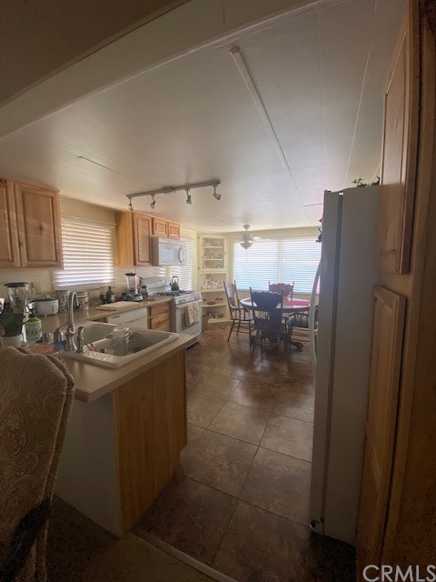 12874 California Street, Unit 48 Yucaipa, CA 92399 - Photo 10 of 21 a kitchen with a sink a refrigerator and chairs