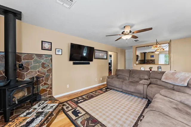 a kitchen with stainless steel appliances granite countertop a refrigerator a sink dishwasher a stove and white countertops with wooden floor