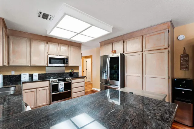 a view of a workspace with furniture and a window