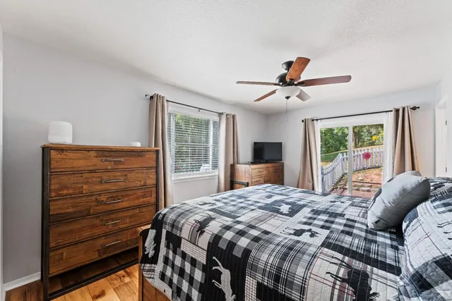 a bedroom with a bed a flat screen tv and a window