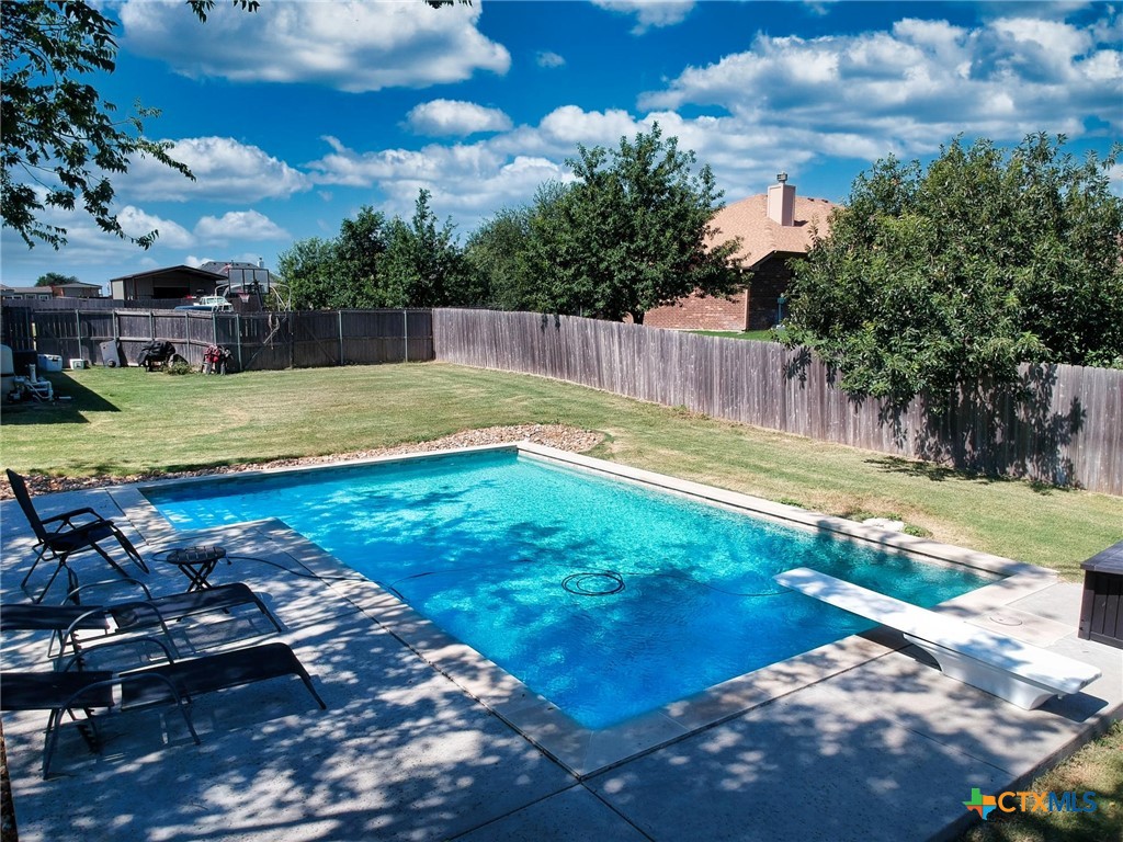 a view of a backyard with swimming pool