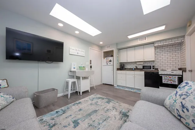 a kitchen with a refrigerator and white cabinets