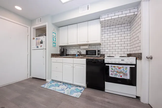a kitchen with a sink a stove a refrigerator and cabinets