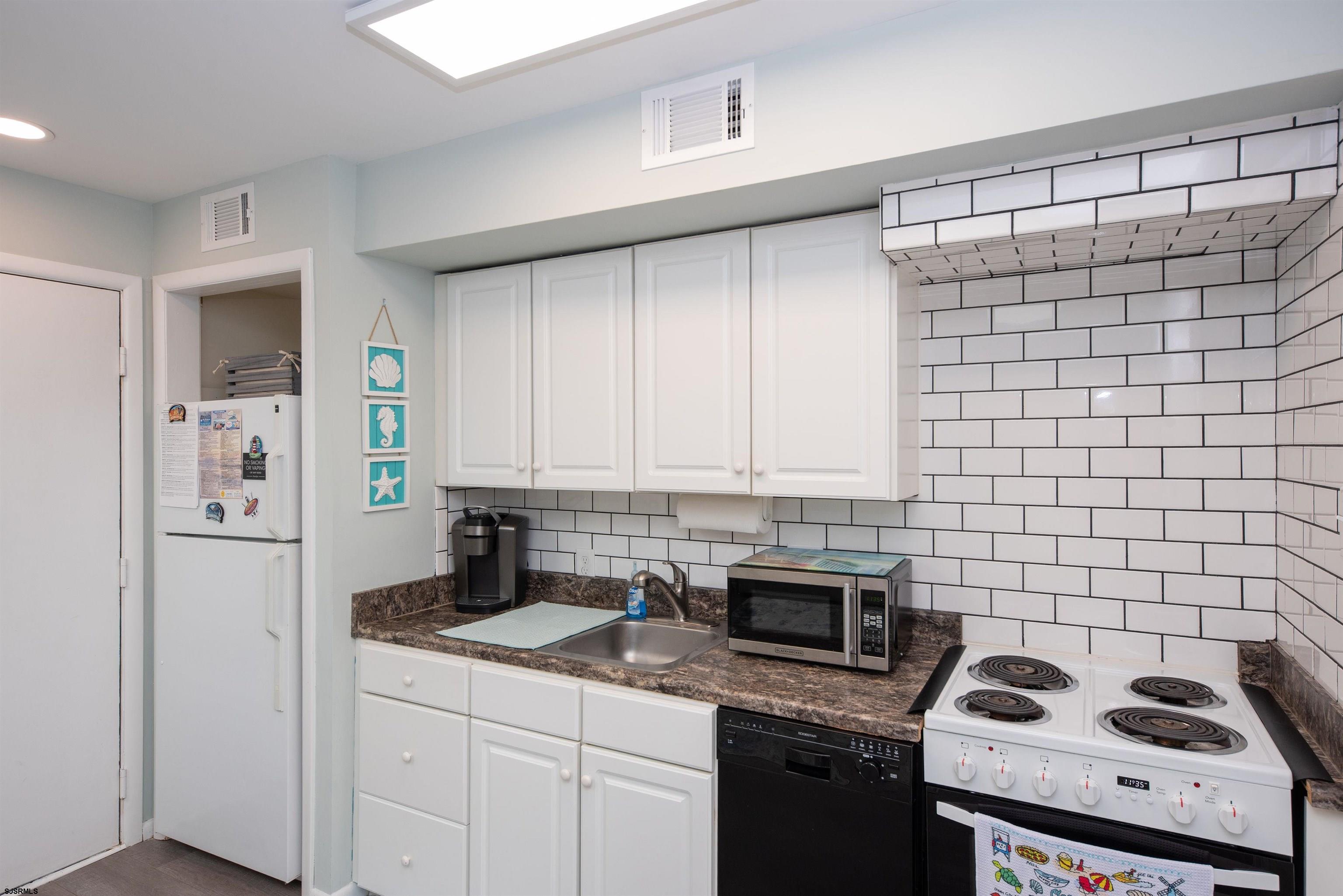 875 Plymouth Place, Unit 35 Ocean City, NJ 08226 - Photo 14 of 60 a kitchen with a sink a stove and cabinets