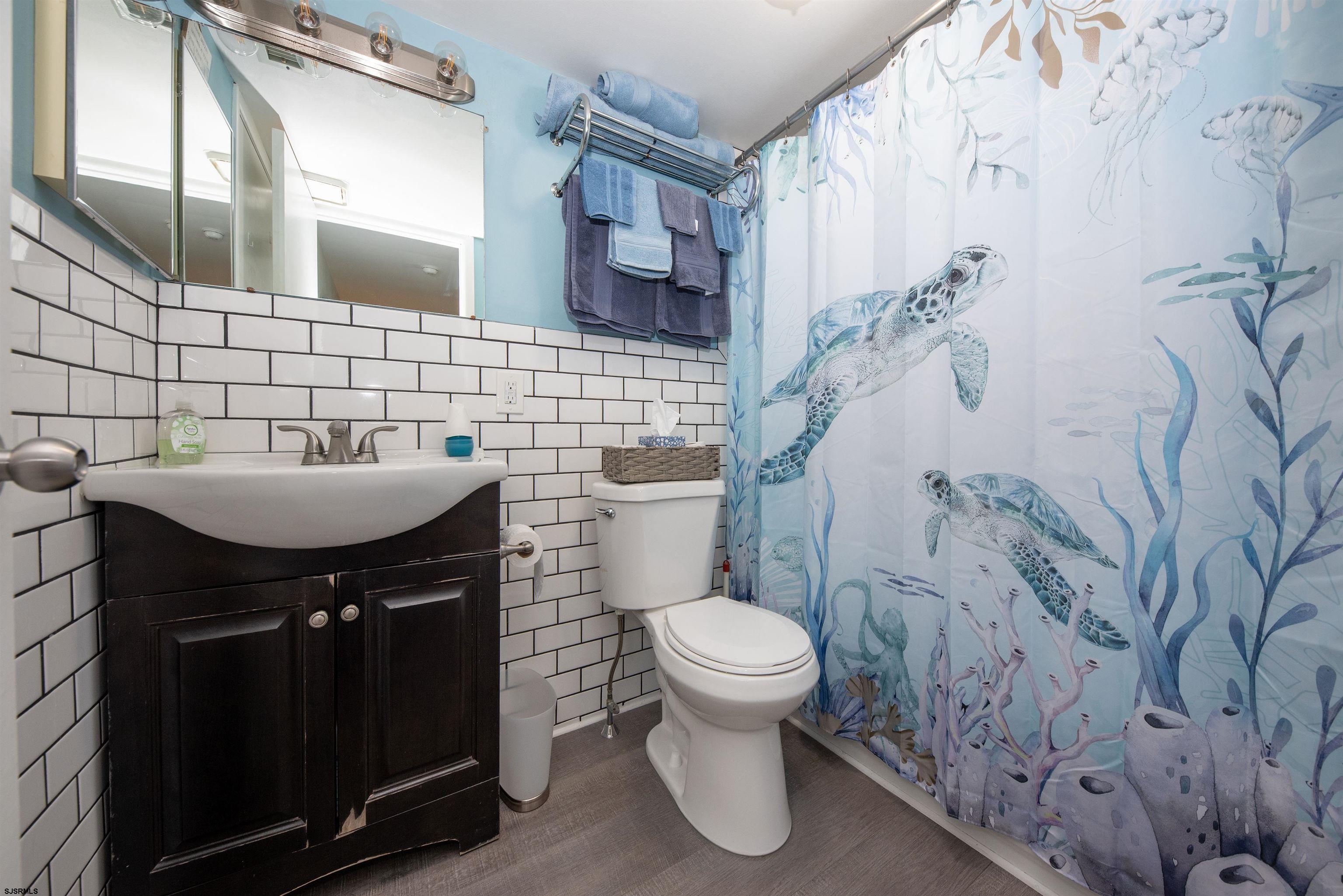 875 Plymouth Place, Unit 35 Ocean City, NJ 08226 - Photo 17 of 60 a bathroom with a sink and mirror with toilet