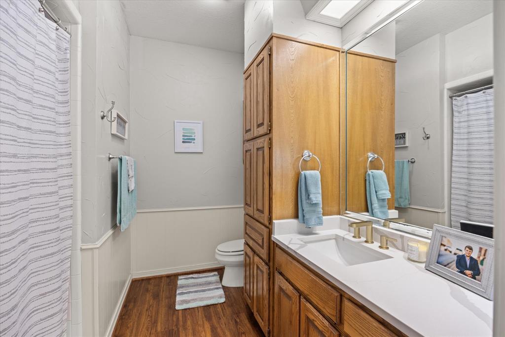 8911 Bontura Road Granbury, TX 76049 - Photo 23 of 39 Bathroom featuring a shower with shower curtain, a wainscoted wall, vanity, and dark wood-style flooring
