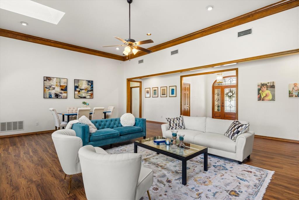 8911 Bontura Road Granbury, TX 76049 - Photo 6 of 39 Living room featuring a ceiling fan, dark wood-style flooring, ornamental molding, a skylight, and recessed lighting