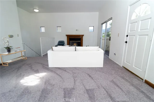 a view of an empty room with a fireplace and a window