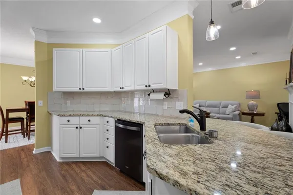 a kitchen with granite countertop a sink a stove and cabinets