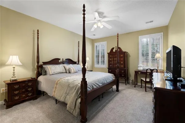 a bedroom with bed tv and window