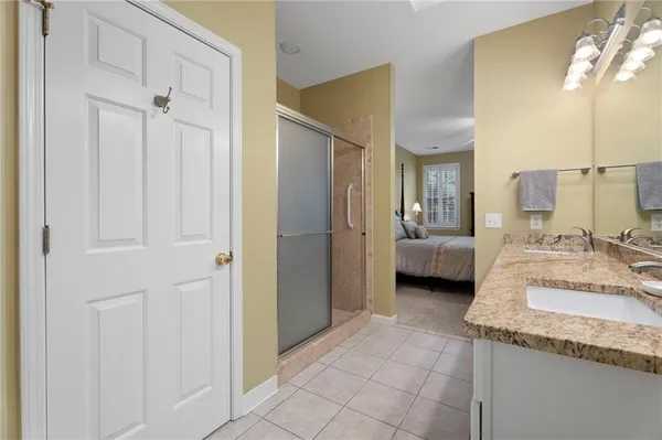 a en suite bathroom with a granite countertop sink and a mirror