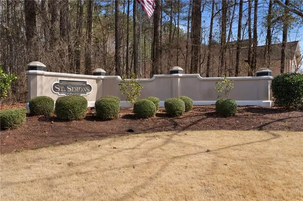 a backyard of a house with potted plants and large trees