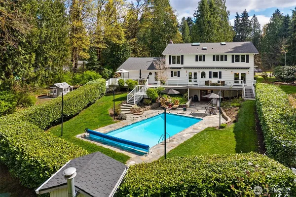 a view of a house with pool and chairs
