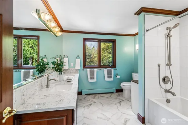 a bathroom with a granite countertop sink a toilet and shower