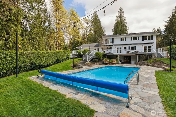 a view of a house with swimming pool and sitting area