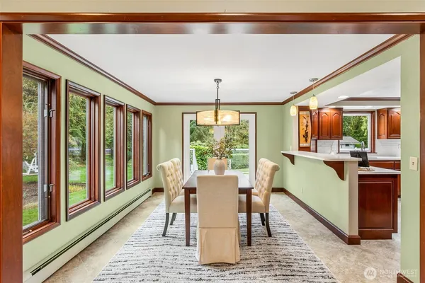 a dining room with furniture a rug and a large window