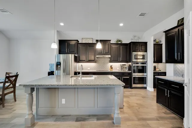 a large kitchen with stainless steel appliances kitchen island granite countertop a large counter top stainless steel appliances and cabinets