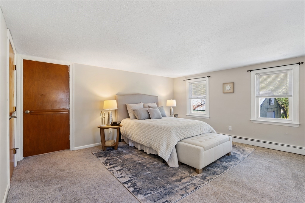 27 Water Street Concord, MA 01742 - Photo 18 of 21 a spacious bedroom with a bed and a couch