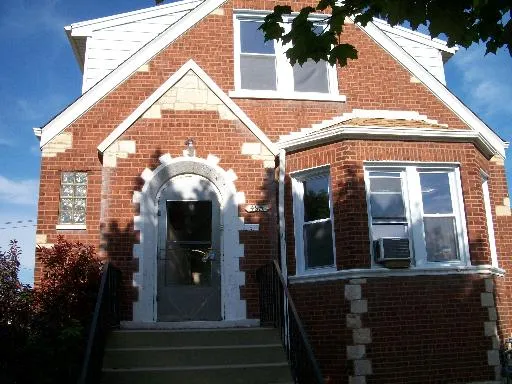 a view of a brick house with potted plants and a large window