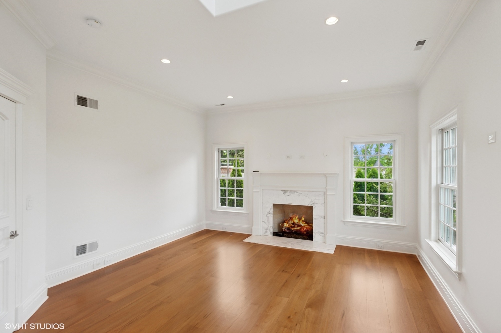 78 Wagner Road Northfield, IL 60093 - Photo 33 of 66 an empty room with wooden floor a fireplace and windows