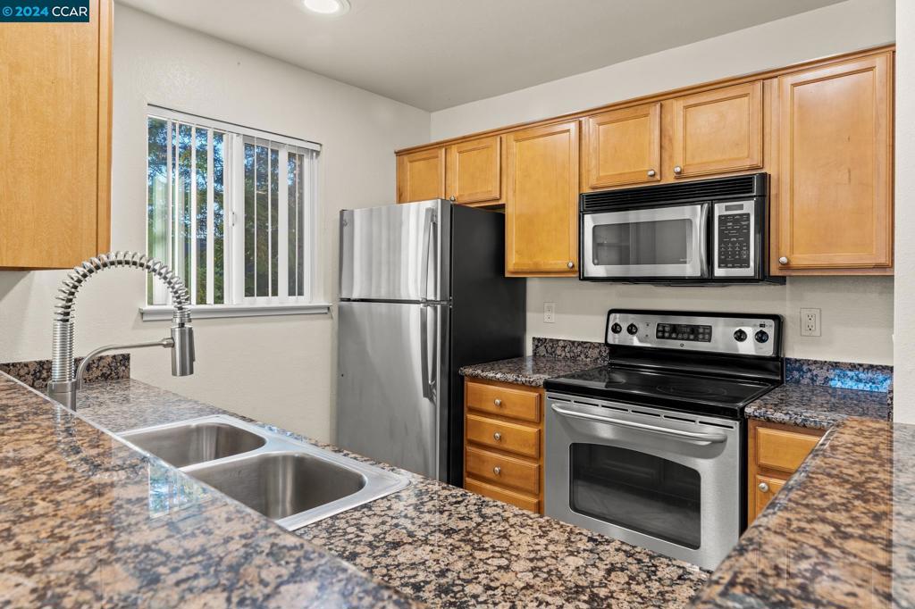 285 Reflections Drive San Ramon, CA 94583 - Photo 8 of 42 a kitchen with granite countertop a sink cabinets and stainless steel appliances