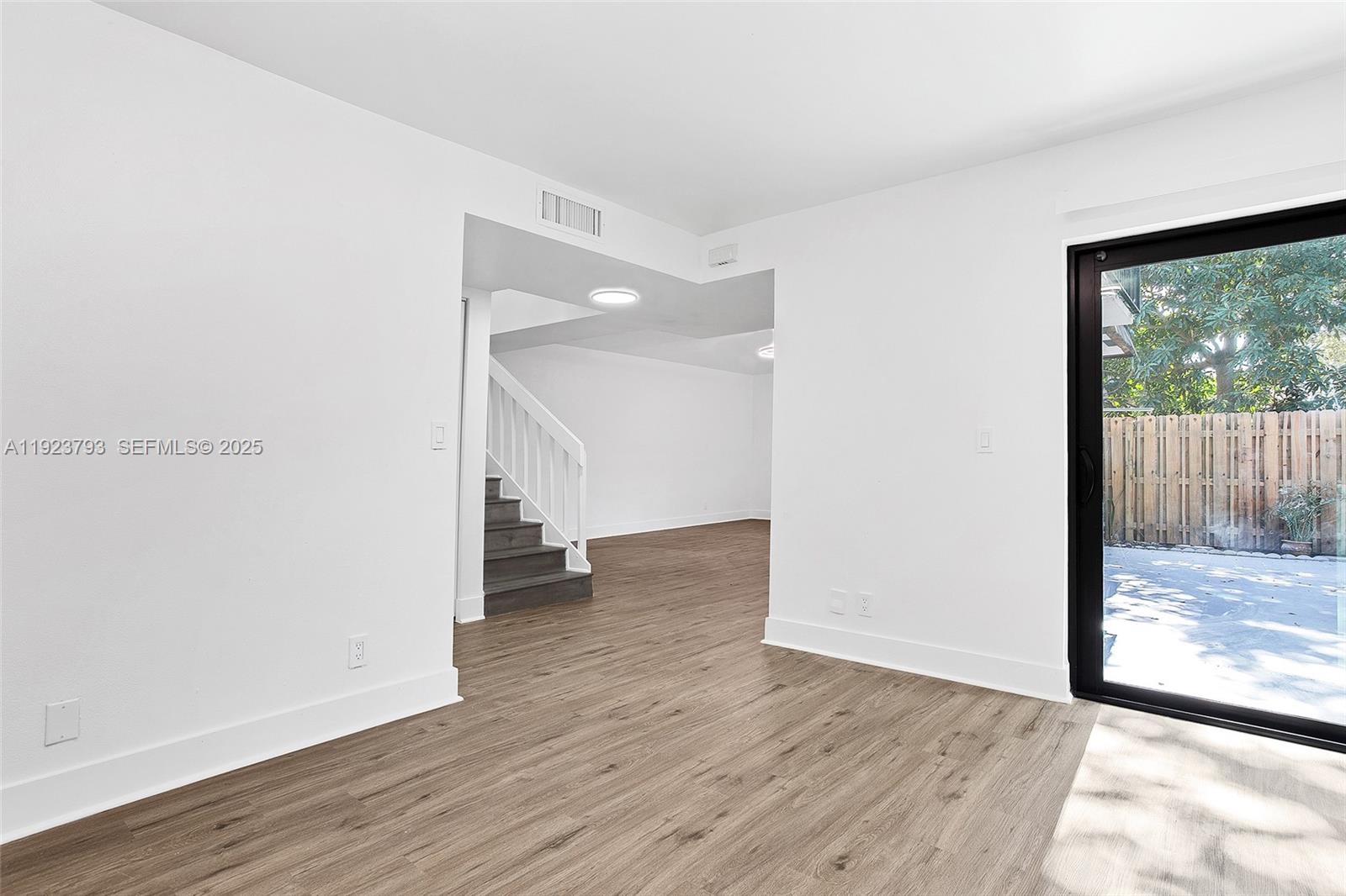 4059 Palm Bay Circle, Unit C West Palm Beach, FL 33406 - Photo 11 of 27 a view of a big room with wooden floor and windows