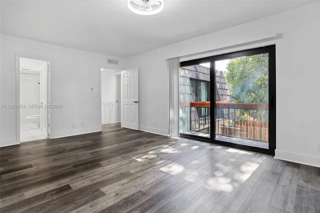 a view of a big room with wooden floor and windows