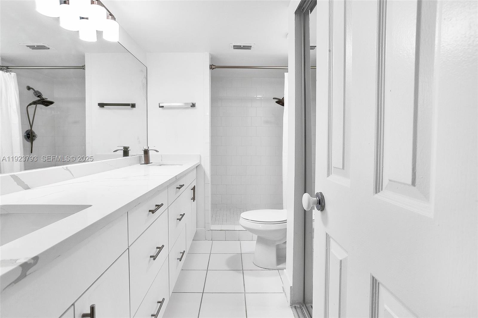 4059 Palm Bay Circle, Unit C West Palm Beach, FL 33406 - Photo 17 of 27 a spacious bathroom with a double vanity sink a toilet and a mirror