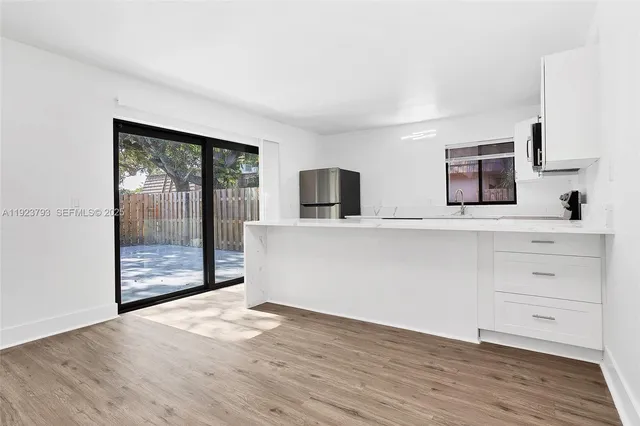 a view of a kitchen with wooden floor and a large window