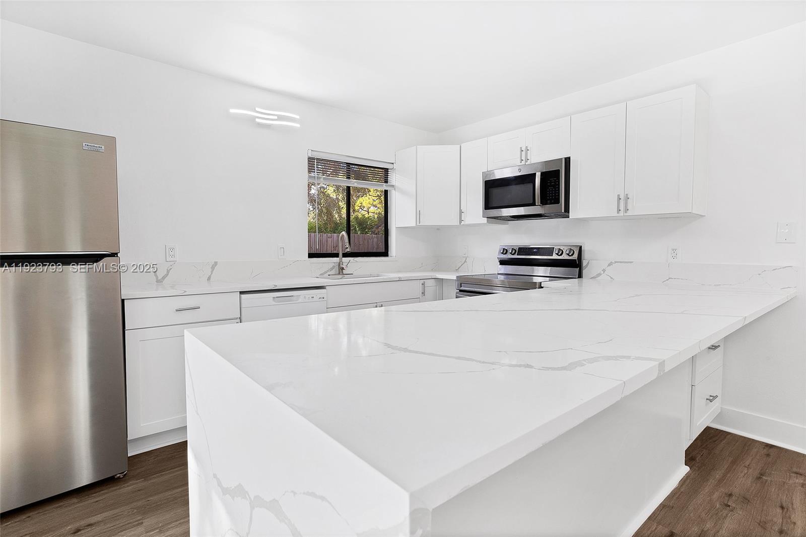 4059 Palm Bay Circle, Unit C West Palm Beach, FL 33406 - Photo 9 of 27 a kitchen with stainless steel appliances a refrigerator sink and microwave