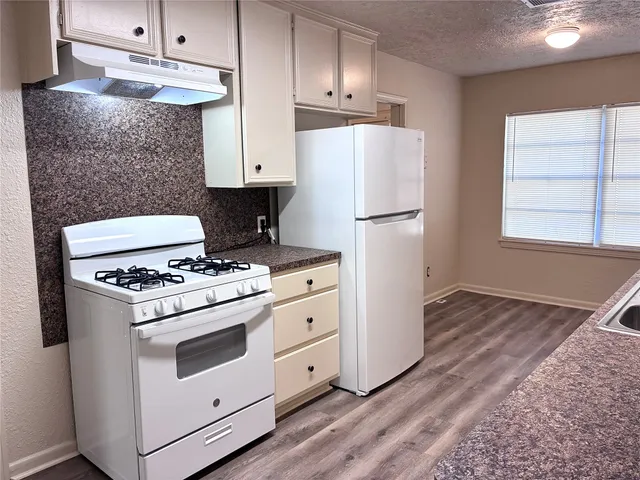 a kitchen with a stove a refrigerator and a sink