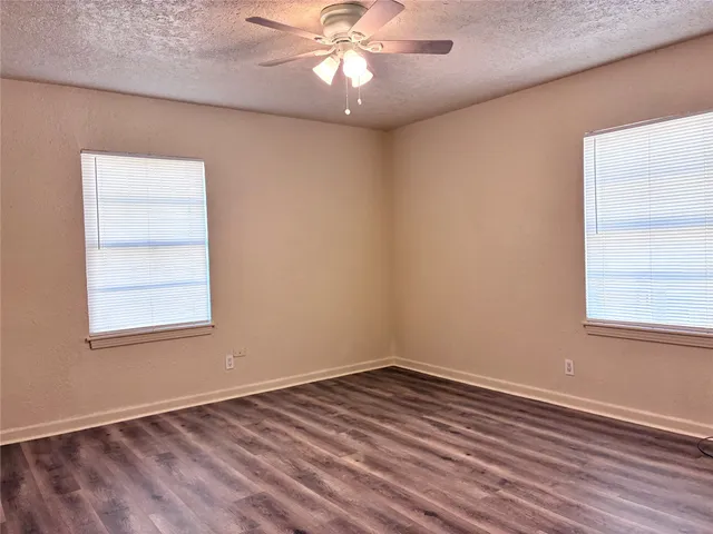 an empty room with a window and wooden floor