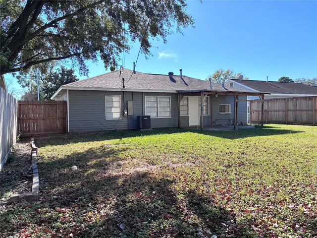 a view of a house with a yard and large tree