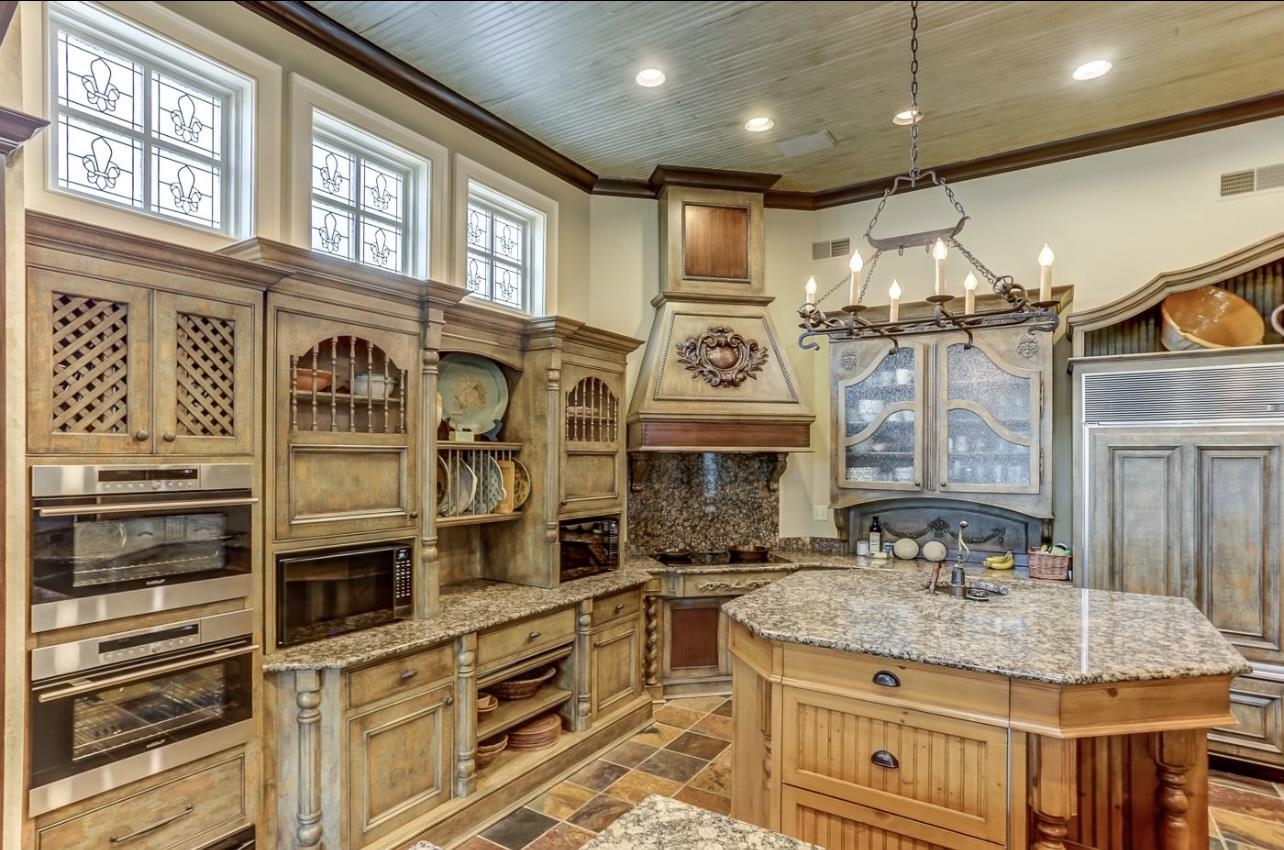 8575 The Island Memphis, TN 38125 - Photo 17 of 40 a kitchen with stainless steel appliances kitchen island granite countertop a stove and cabinets