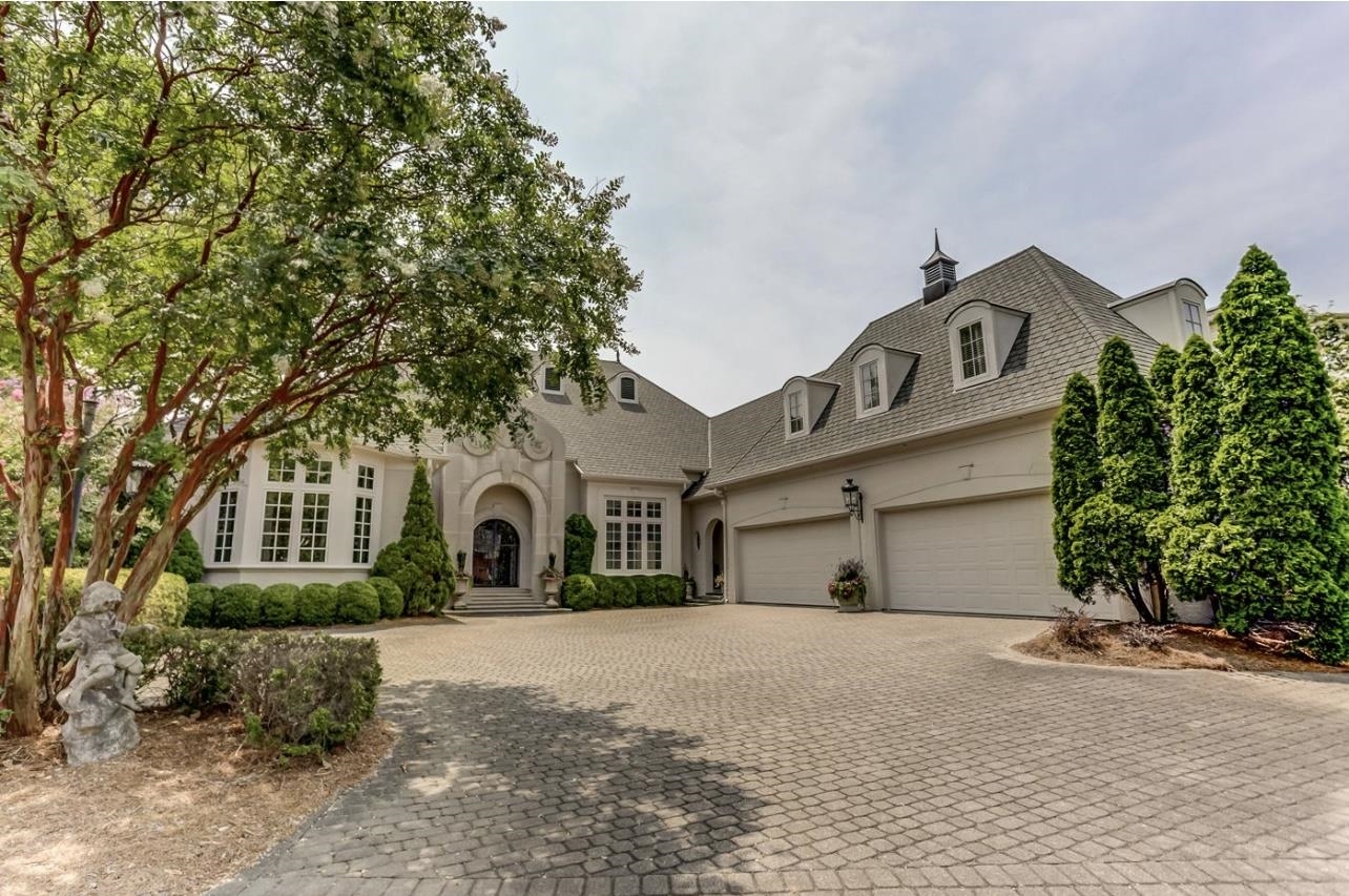 8575 The Island Memphis, TN 38125 - Photo 34 of 40 a front view of a house with a yard and garage