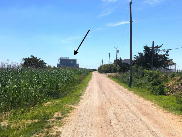 a white house with a yard and ocean view