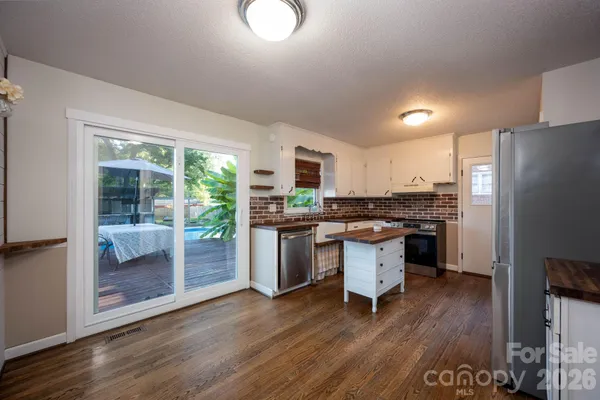 a kitchen with a refrigerator and a stove top oven