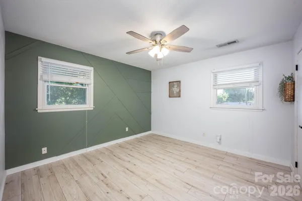 a view of a big room with wooden floor and windows