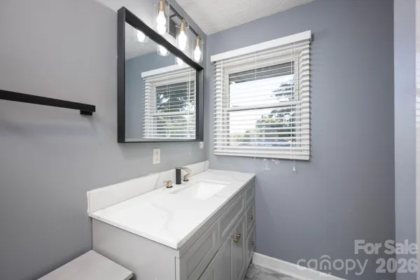 a bathroom with a sink a mirror and a window