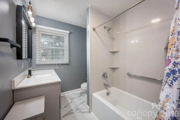 a bathroom with a tub sink and mirror