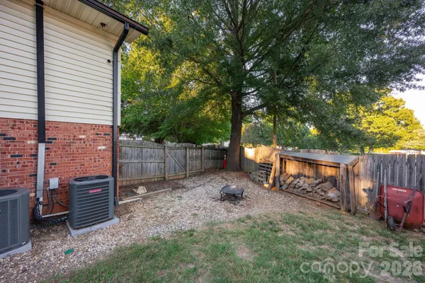 a backyard of a house with barbeque oven and fence