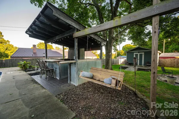 a view of a wooden bench sitting in backyard of house